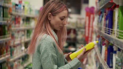 Mujer-Lee-La-Etiqueta-De-Productos-Para-El-Hogar-En-El-Supermercado