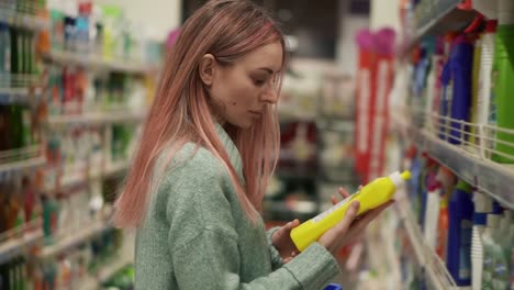 woman reads label of household products in supermarket