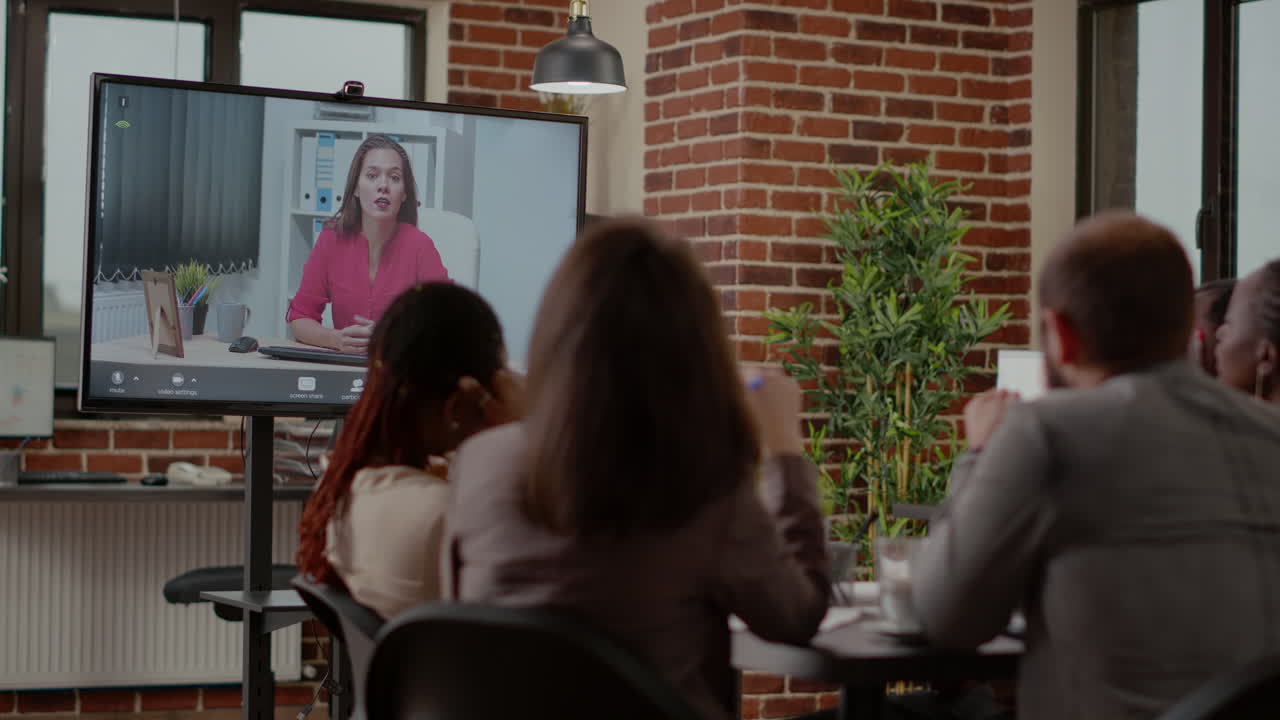 Diverse team of colleagues using video conference call to chat with woman