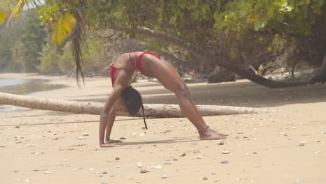 increíble pose de contorsión de una niña africana en bikini en una playa