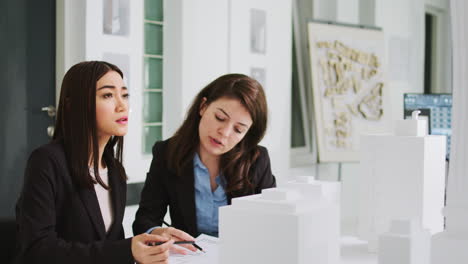 architectural agency workers taking notes on blueprints