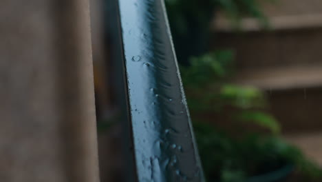 Raindrops-on-Metal-Railing,-Shallow-Focus