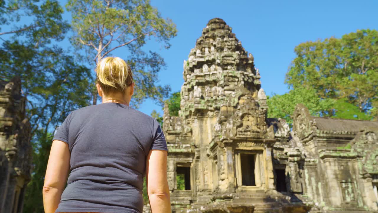 보디아 시리프에 있는 앙코르와트 복합 건물 안의 마논 사원을 향해 걸어가는 젊은 여성을 추적하고 있다.