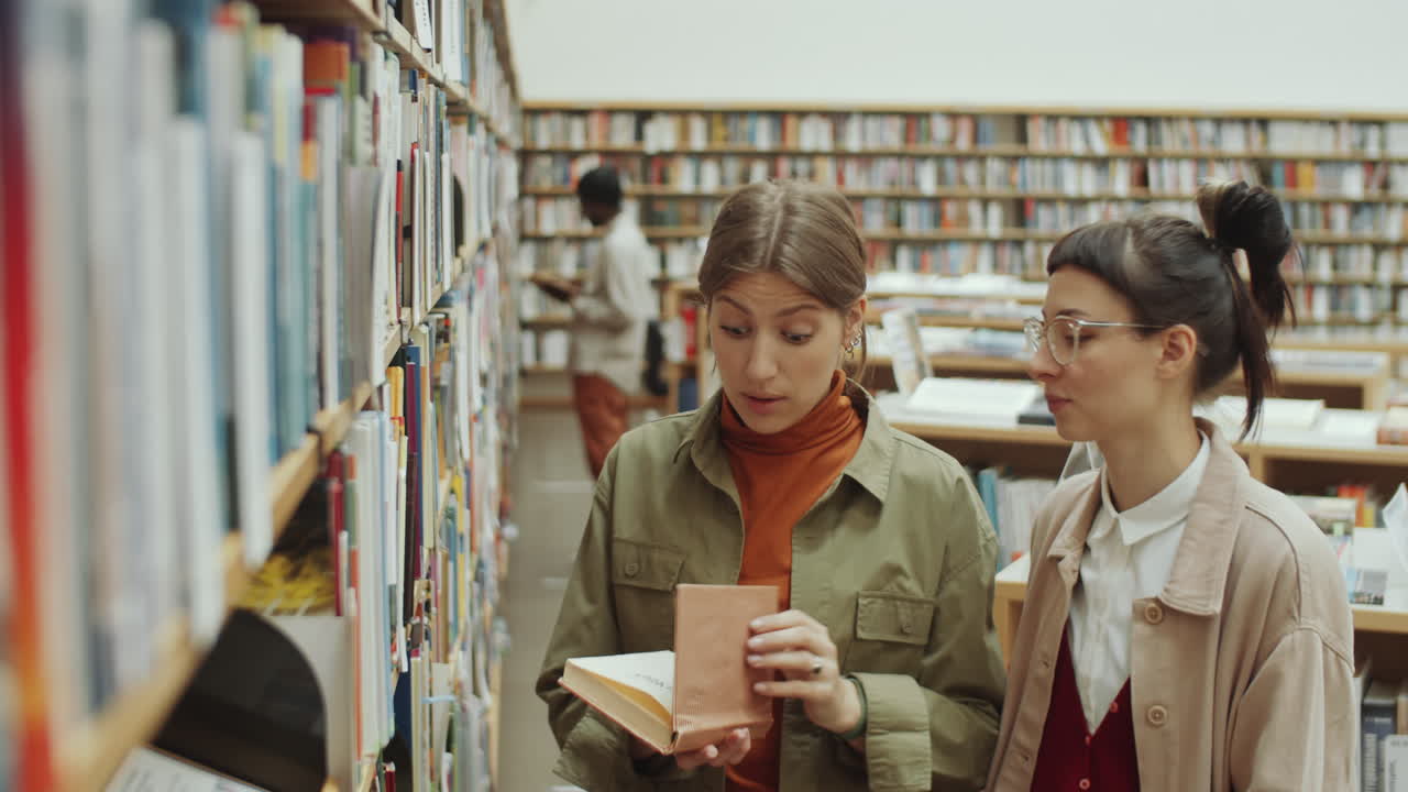 Young Women Choosing Book in Library