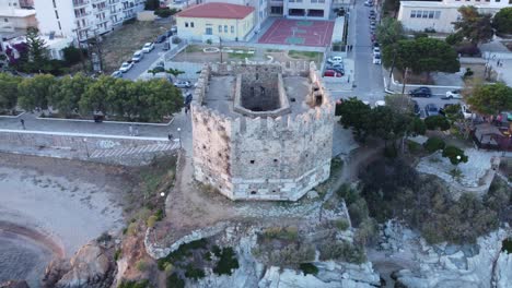 Torre-Medieval-Al-Borde-Del-Mar-Protegiendo-Un-Pequeño-Pueblo-|-Toma-Aérea-De-Una-Pequeña-Fortaleza-Medieval-|-4k