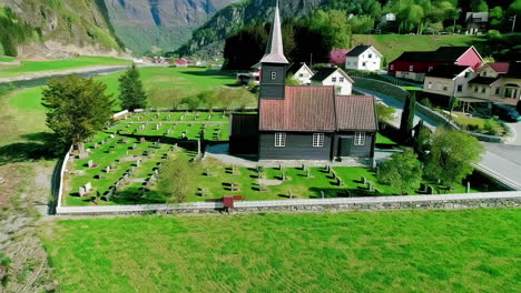 vista aérea de la iglesia y el cementerio de flam, punto de referencia del pueblo en un soleado día de verano, noruega, disparo de avión no tripulado
