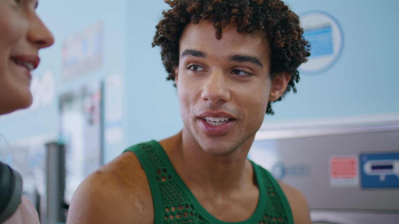 un adolescente rizado hablando con un amigo de cerca. un tipo amigable disfruta de la conversación.