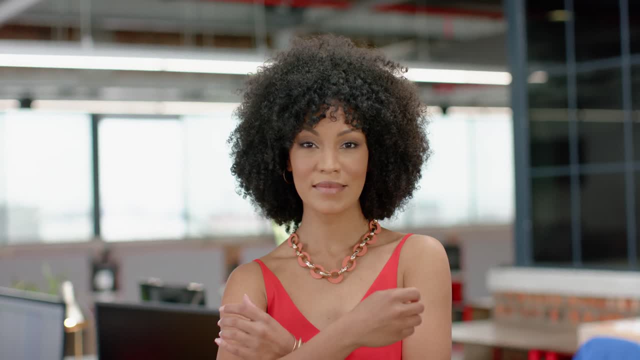 retrato de una mujer afroamericana sonriendo mientras está de pie en la oficina