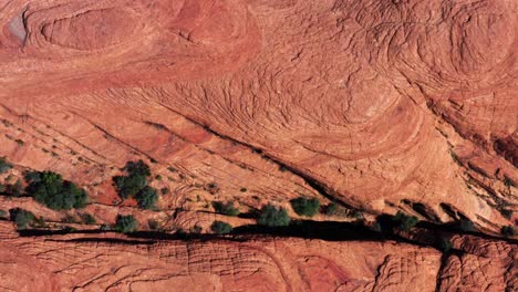 gorgeous aerial drone top bird's eye view of incredible red petrified sand dunes with beautiful line textures in the desert of the snow canyon state park in southern utah