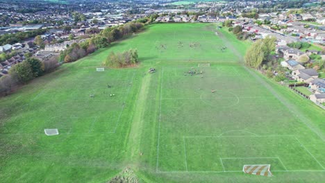 aerial drone video footage of open playing fields situated on the summit of a hill