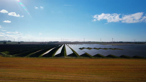 aerial flying towards large scale solar farm on clear sunny day