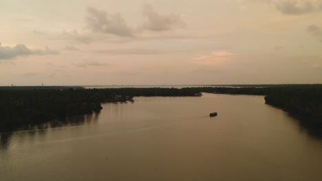 Hermosa-Toma-Aérea-De-Un-Lago-Vembanadu-De-Remanso,-Líneas-De-Agua,-Puesta-De-Sol-Crepuscular,-Cocoteros,-Transporte-De-Agua,-Nubes,-Reflación,-Crucero-En-Barco