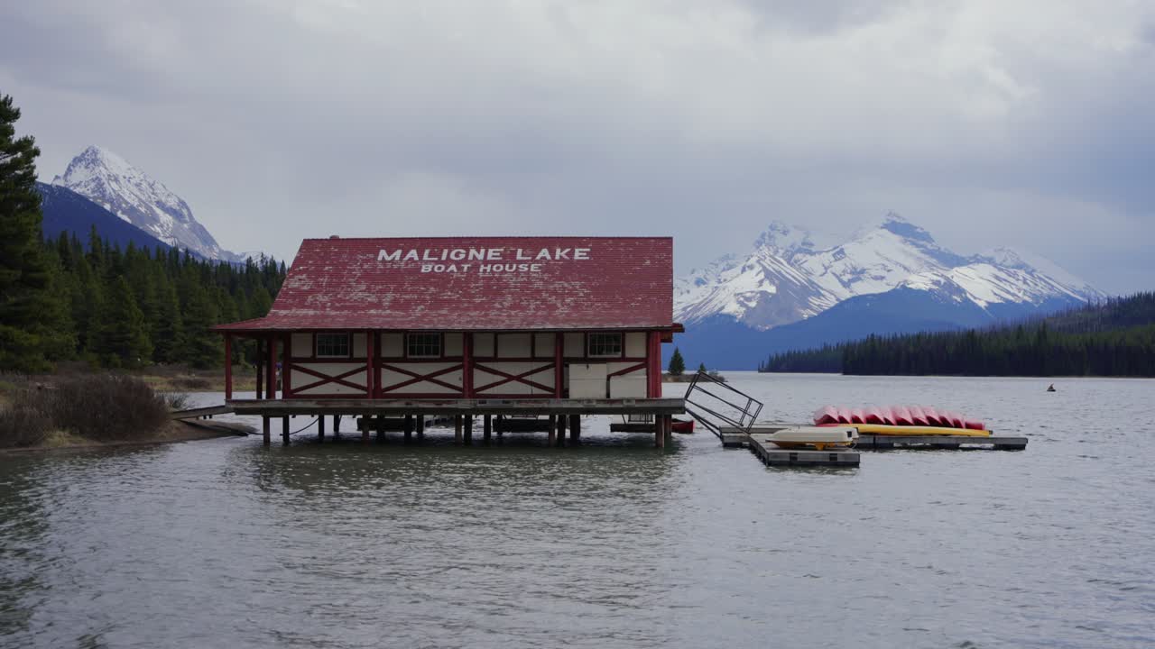 Capanna delle barche del lago Maligne con montagne innevate nel Parco Nazionale Jasper, Canada
