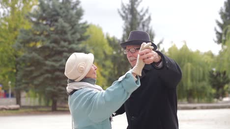 old european man and woman dancing together in park standing old european man and woman dancing together in park standing healthy lifestyle concept