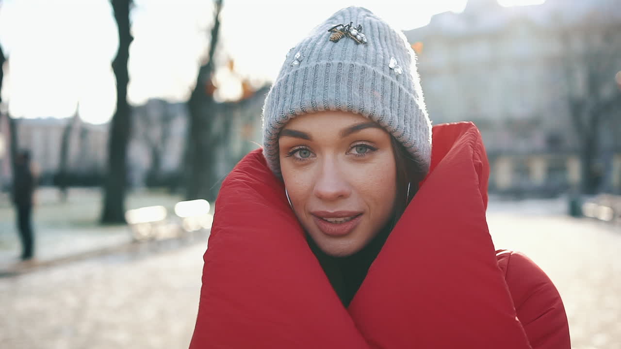 Woman in winter hat and red coat outdoors