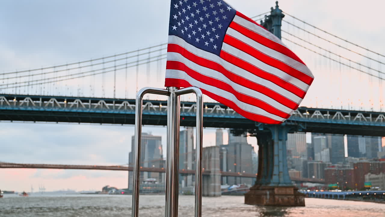 Bandiera americana che sventola sulla prua della barca. Famoso ponte di Manhattan e skyline di New York sullo sfondo