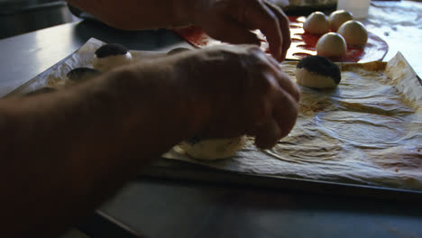 Chef-placing-unbaked-buns-on-the-tray-4k