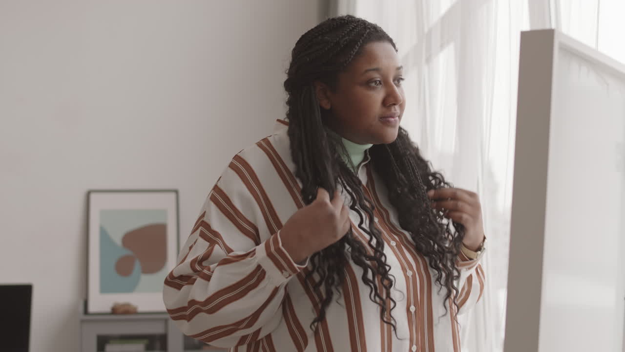 African Woman Tiding Her Hair before Going Out