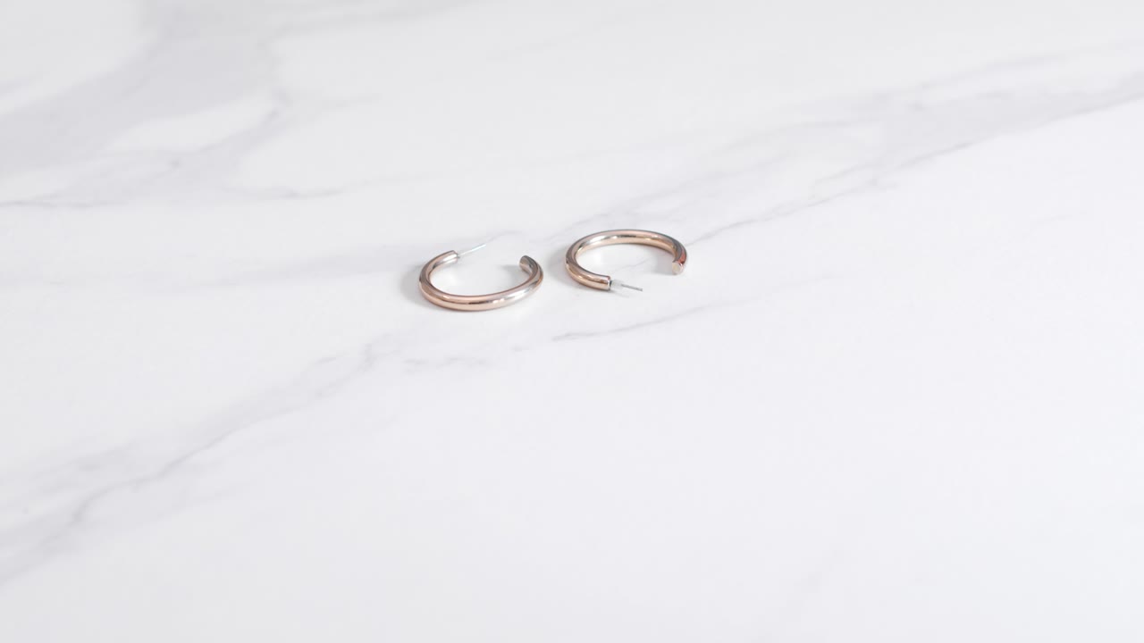 Woman Put Down Pair Of Round Gold Earrings On The Table