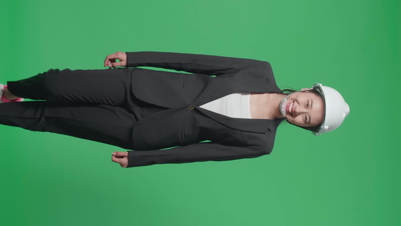 Smiling Asian Female Engineer Walking In The Green Screen Studio