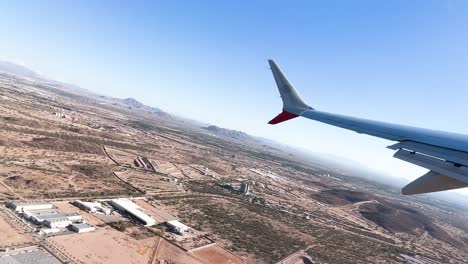 vista por la ventana del asiento de un avión despegando en el desierto de sonora