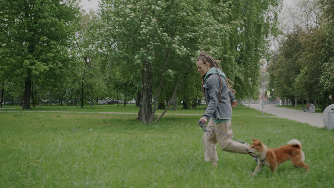 Woman Running with Dog in Park
