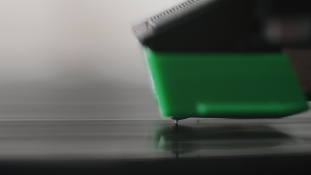 Close-Up of Stylus Needle Tracking Grooves of Vinyl Record Spinning on Turntable