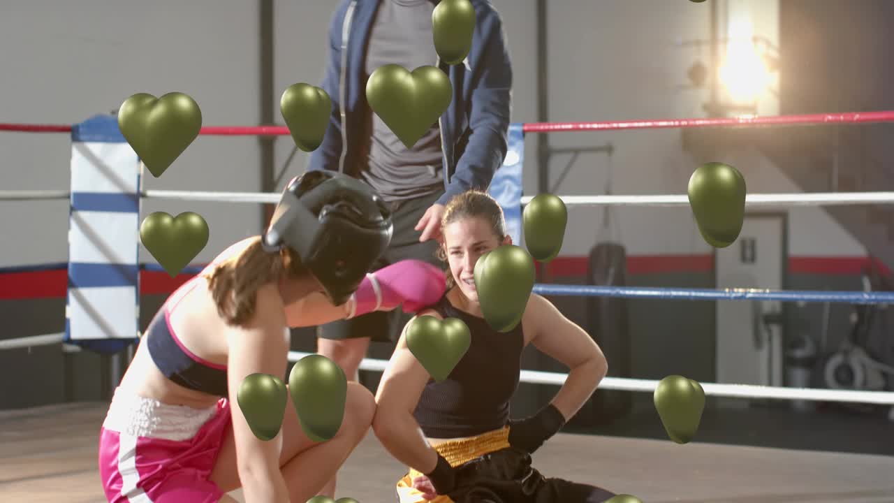 Female boxer sitting up after falling while coach checking in boxing ring, green hearts floating