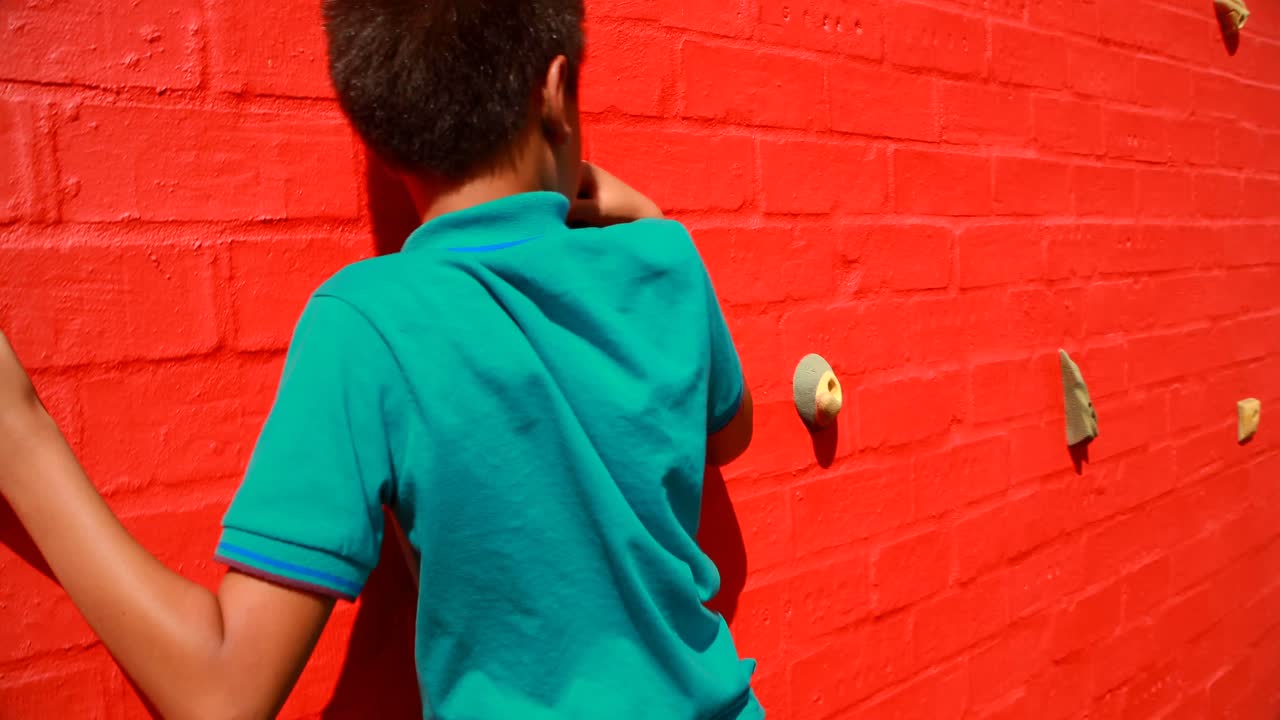 primer plano de un escolar escalando la pared 4k