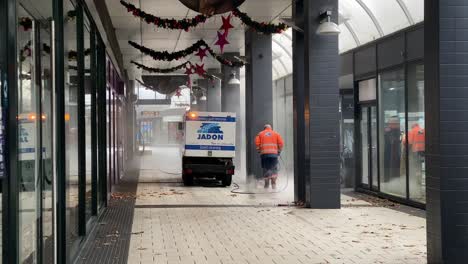 cleaning company power washing shopping street while shops are under lockdown.