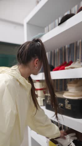 woman looking at vintage clothing and accessories on shelves