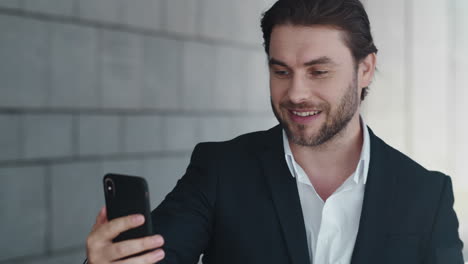 Business-man-waving-hand-at-phone-camera-outside.-professional-call-video