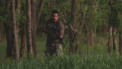 soldado hispano con rifle mira a su alrededor mientras camina en el desierto
