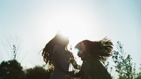silueta de hermanas jugando en un campo al atardecer