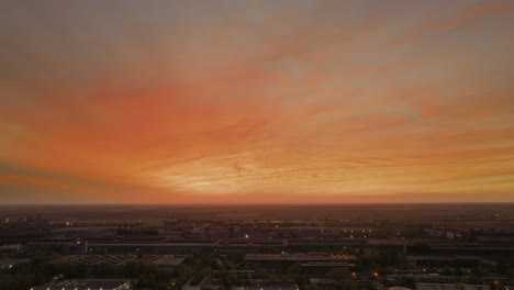 Drone-high-dynamic-range-shot-with-an-enchanting-spectacle-of-a-radiant,-warm-sunset-casting-its-golden-embrace-over-a-weathered,-old-industrial-district-4K50Fps-Cinematic-grade