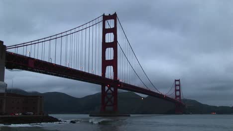 surf rolls over rocks under historic golden gate bridge in san francisco bay