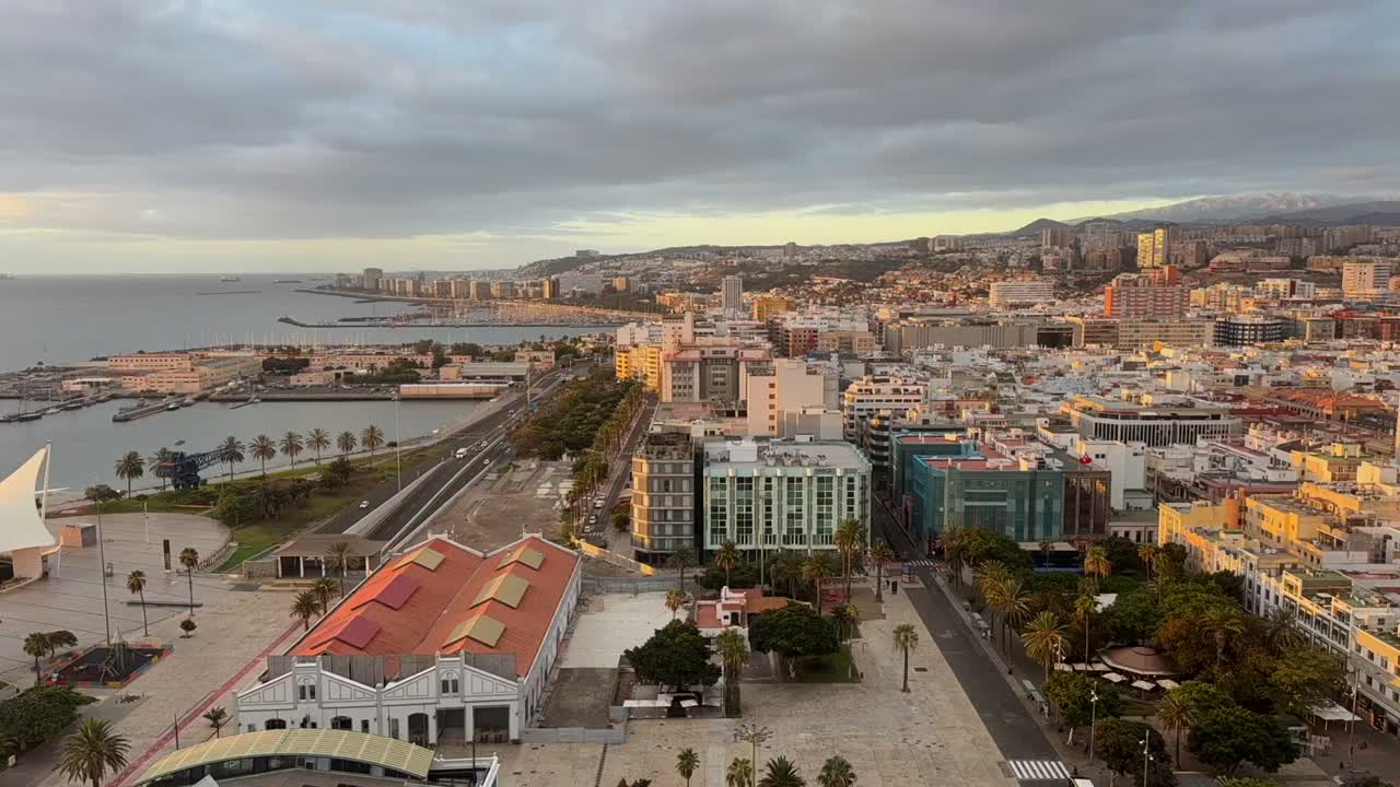An elevated timelapse of Las Palmas de Gran Canaria city, Canary Islands, with a view of the city and coast bathed by the sunrise light. 4K