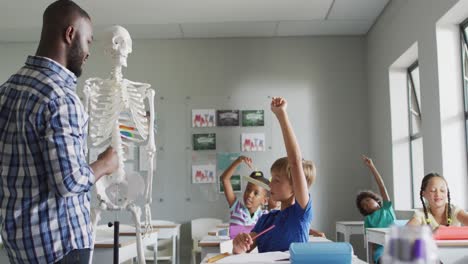 video of happy african american teacher with class of diverse pupils during anatomy lesson