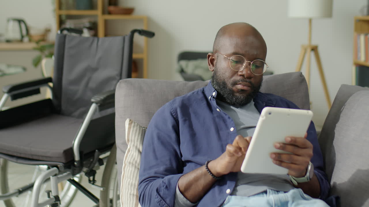 Black Man with Disability Using Tablet at Home
