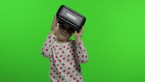 child girl using vr helmet to play simulation game app. watch virtual reality 3d video. chroma key