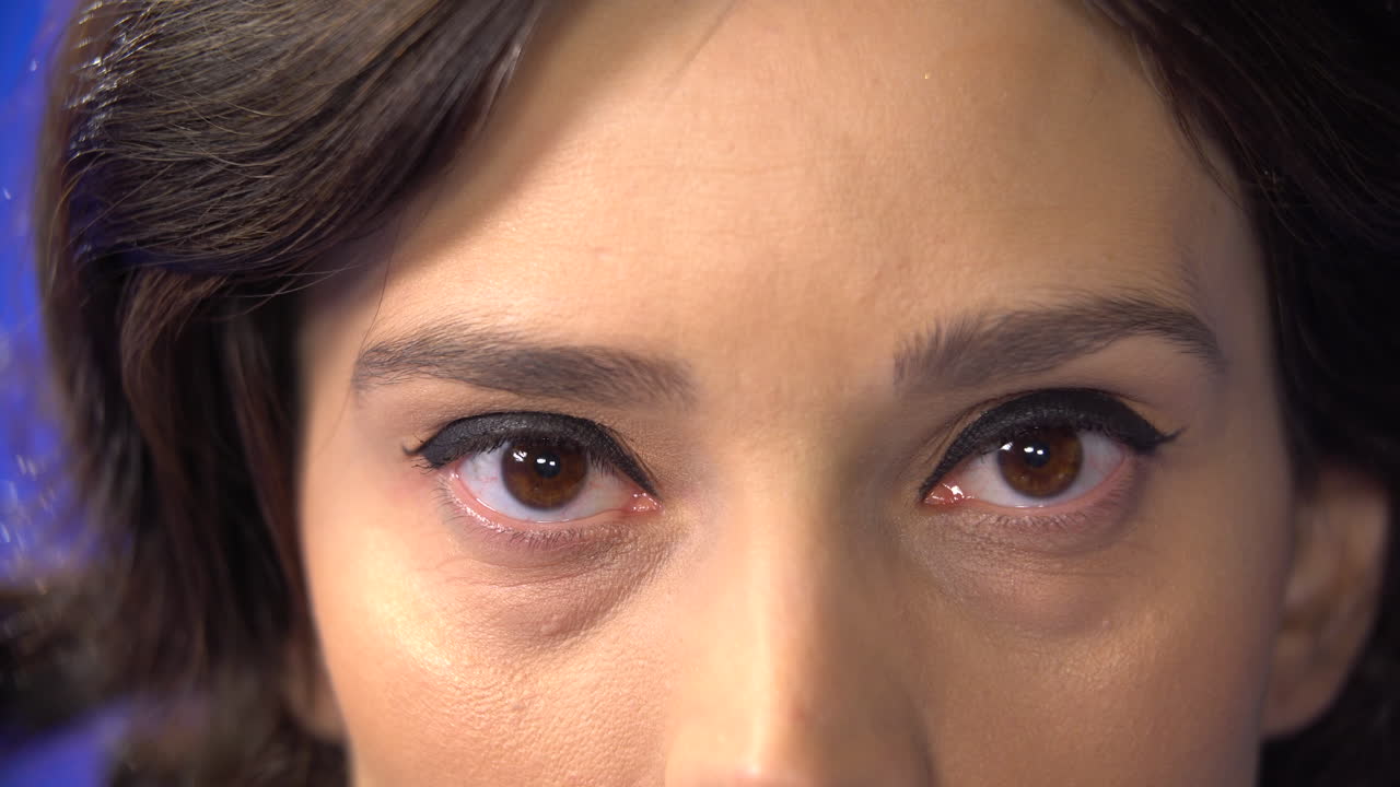 천천히 눈을 뜨고 카메라를 바라보는 아름다운 여성의 여성 눈