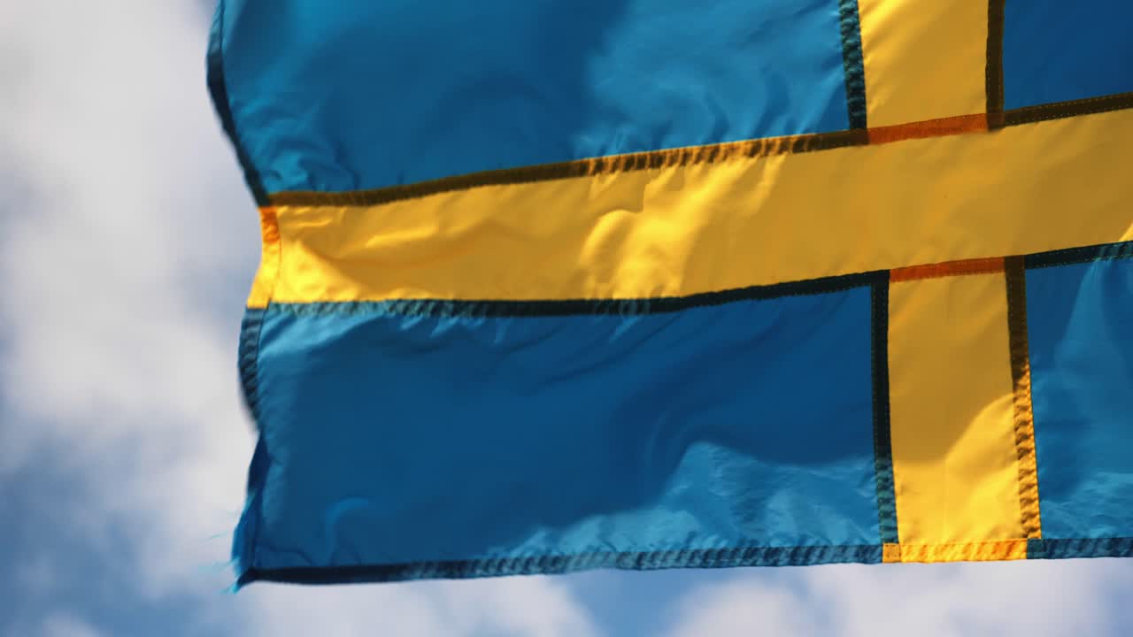 Swedish flag waving in the sky with clouds and wind in Gothenburg city
