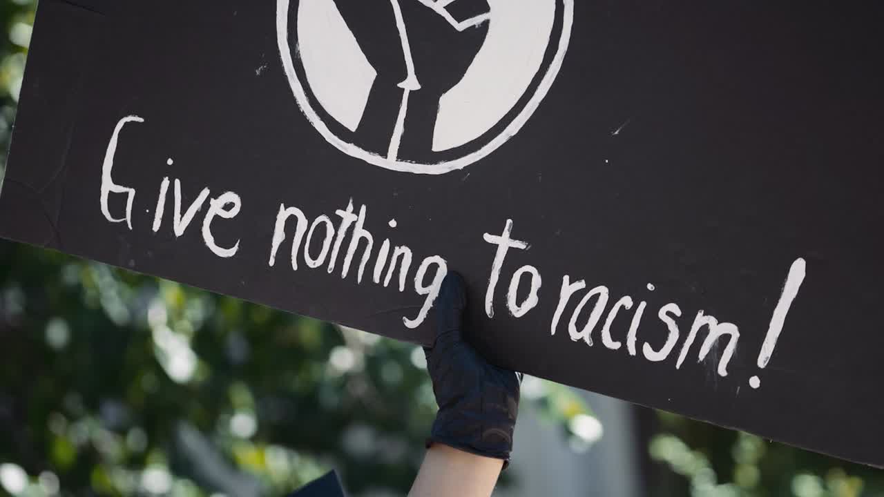 High Resolution Editorial Solidarity BIPOC Freedom 4K Video White Painted Give Nothing to Racism Black Lives Matter Crowd Hand Made Justice Demonstration Protest Sign Caucasian Arm and Glove