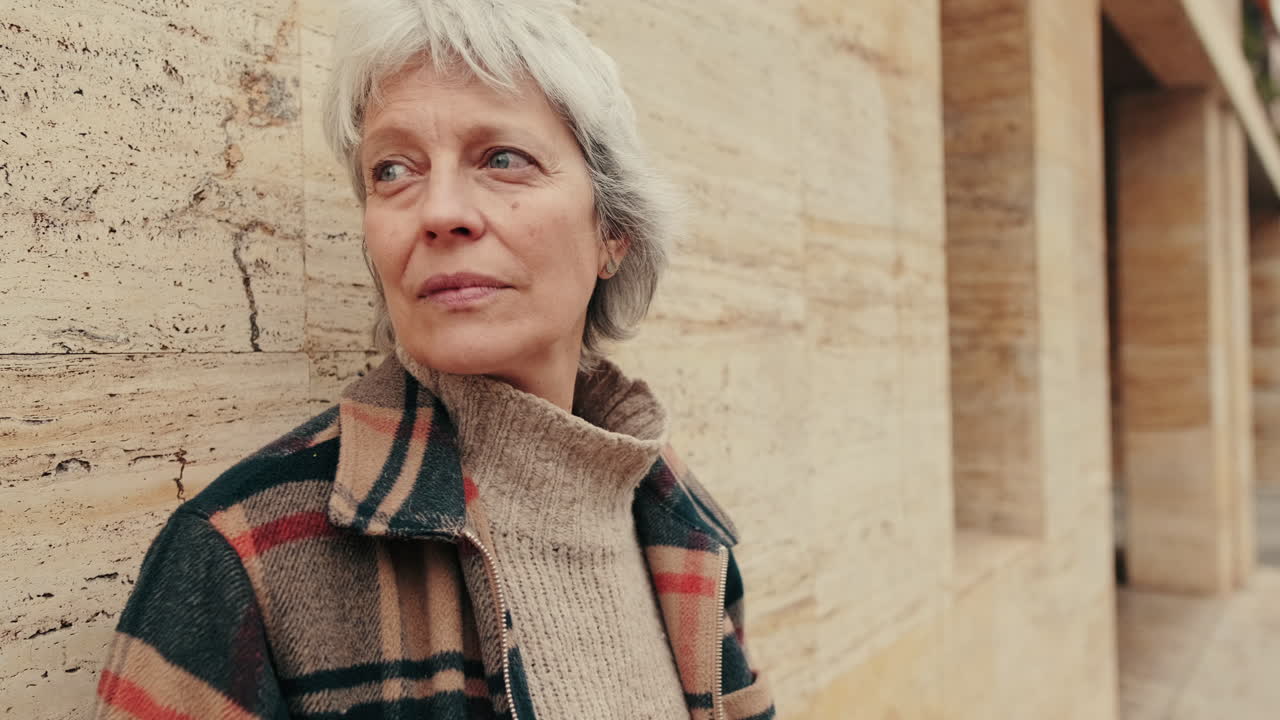 Close-up of Thoughtful Senior Woman Leaning Against Stone Wall