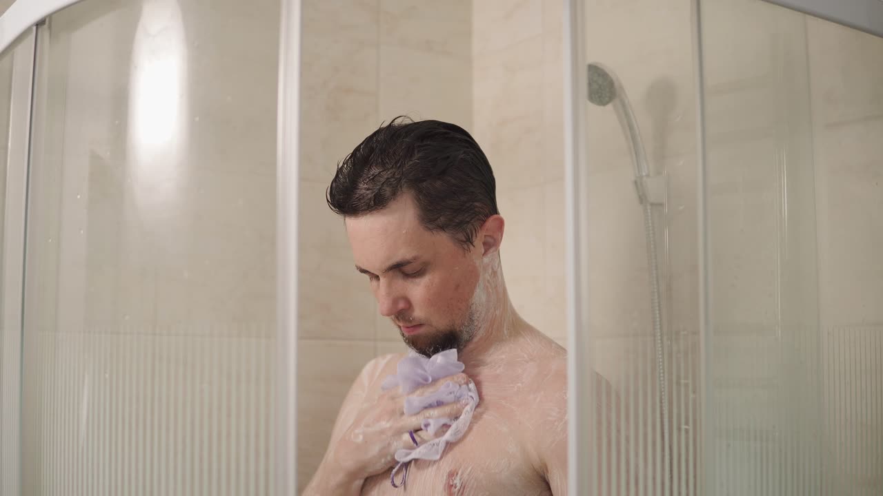 hombre bañándose en una moderna cabina de ducha de vidrio