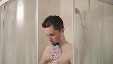 hombre bañándose en una moderna cabina de ducha de vidrio