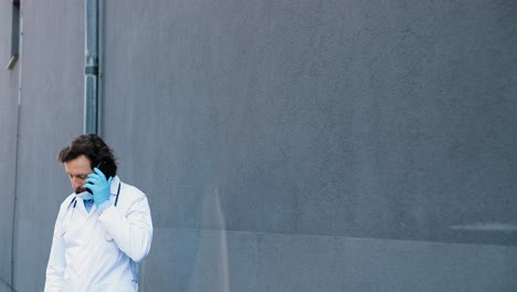 male doctor talking on mobile phone and starting to run to help patient