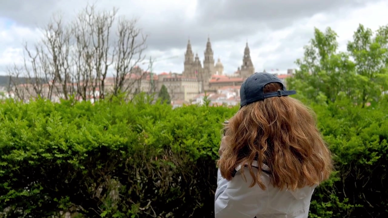 Donna turista in viaggio in Galizia che fotografa la Cattedrale di Santiago de Compostela