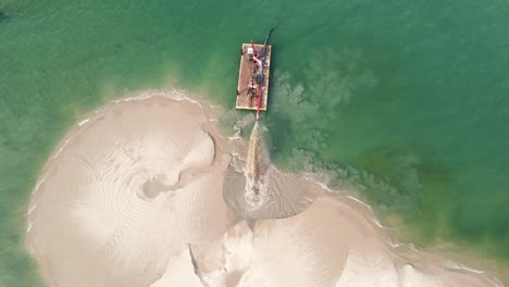 still bird's eye view of a barge reconstructing sandy shore