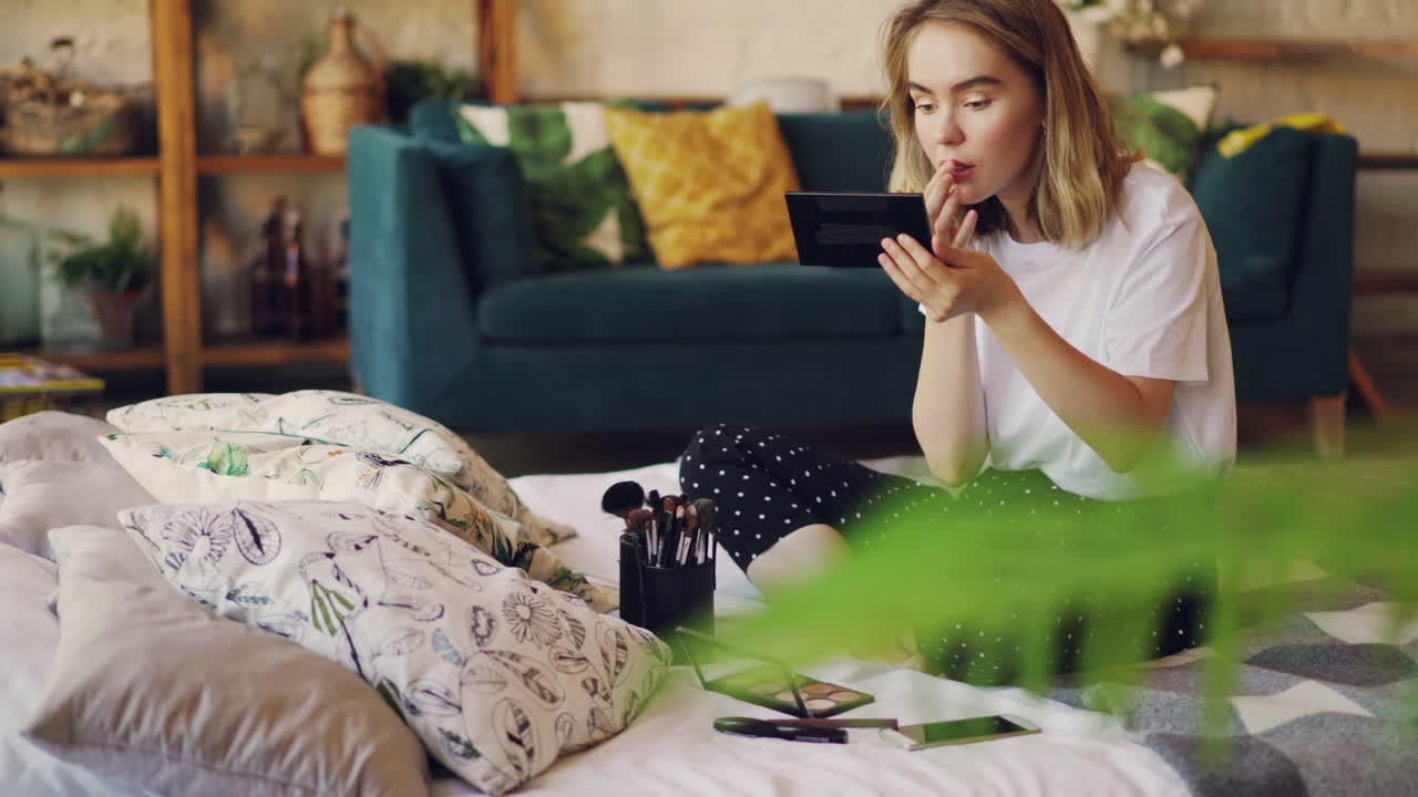 женщина наносит помаду дома